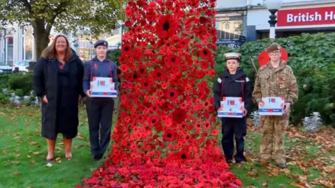 Stand Up For Southport Sefton council leader, councillor Marion Atkinson to the right, with poppy volunteers from the Royal British Legion, stand next to the poppy drape