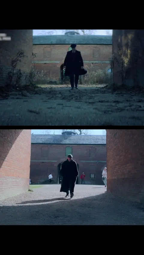 Two images show the same walkway between tall brick walls, taken from similar angles but in different lighting and seasons. In both shots, a single person wearing dark clothing walks toward the camera from the archway of a brick building in the background. The top image looks darker and more overgrown, while the bottom image is brighter, with clearer ground and a few other people visible in the distance.
