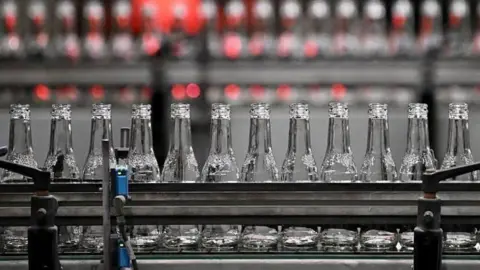 Glass bottles on a conveyor belt.