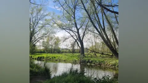 Kelly Robinson Photo shows a river with trees and grassland around it