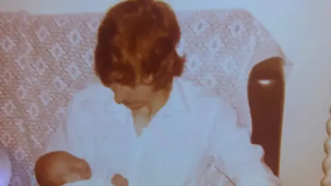 Supplied An old picture of Ian Coates holding his son Darren as a baby in 1980 