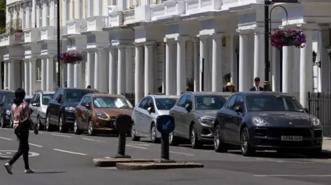 A row of parked cars in a London street. 
