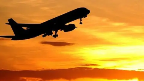 PA A plane flying towards the sunset