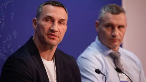 Getty Images Former heavyweight champion boxer Vitali Klitschko, Mayor of Kyiv, right, and his brother Wladimir Klitschko during a panel session on the opening day of the World Economic Forum (WEF) in Davos, Switzerland, Monday, May 23, 2022.