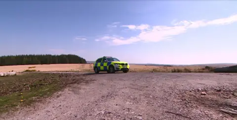 A police car sits on a plateau on Dartmoor