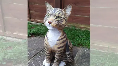 Supplied A sculpture of a cat made out of newspaper and tinfoil, in a garden