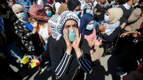 Reuters A student wears a face mask at an anti-government protest in Basra, Iraq (5 March 2020)