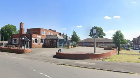 Google A Google Map photo of the Red Lion pub on Batley Road. The venue has a large car park and is located next to a busy road.