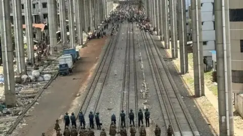 BBC standoff between people and police under a railway line in Dhaka