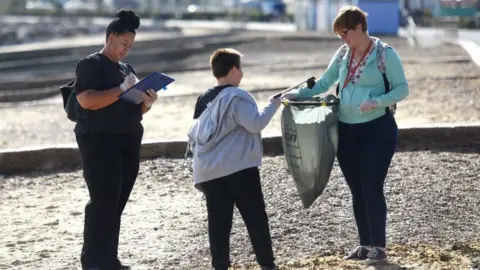 Gill Moon People picking up litter on a beach