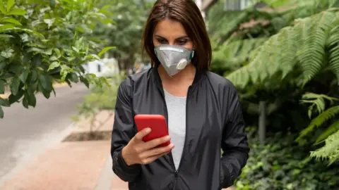 Getty Images Woman in mask on app