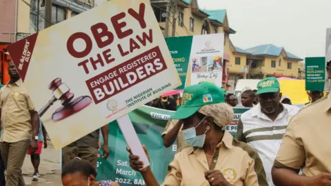 Getty Images Institut Pembangunan Nigeria bekerja sama dengan Building Collapse Prevention Guild mengadakan aksi jalan kaki melawan keruntuhan bangunan, dengan tema Membangun dengan Integritas, sebagai bagian dari kegiatan yang menandai Hari Pembangun 2022 di Ikeja, Lagos, Nigeria, pada Sabtu, 12 Maret 2022.