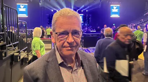 grey haired man with glasses in shirt and jacket 