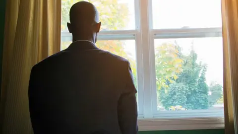 Getty Images Man staring out of window