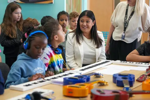Getty Images Culture Secretary Lisa Nandy in a classroom full of children playing music
