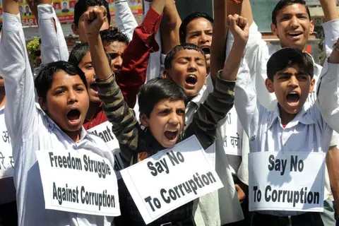 AFP via Getty Images Indian students shout anti-corruption slogans in support of veteran Indian social activist, Anna Hazare at a garden in Amritsar on April 8, 2011.