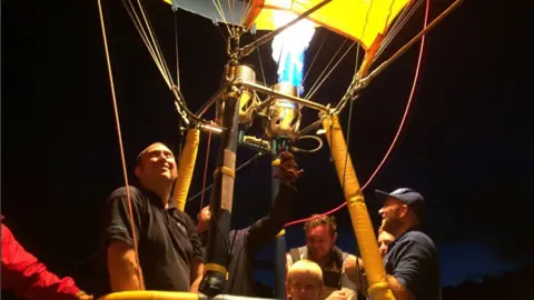 BBC Pilot in balloon operates burner