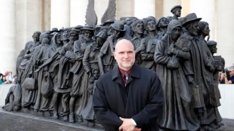 Reuters Timothy P. Schmalz stands in front of the sculpture