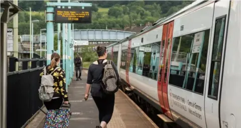 Getty Images Passengers at train station platform