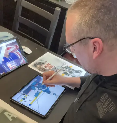 Alex Douglas Alex Douglas uses a pen and an iPad to recreate an image of a women's hockey player, while sitting at a desk