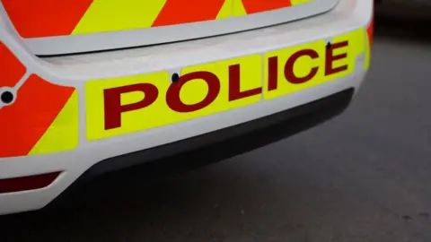 Back of a police car. The word police is printed on the back