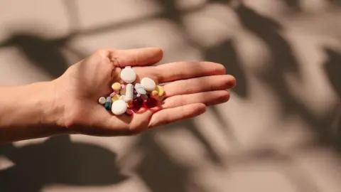Getty Images Stock image of someone with a palm full of supplements