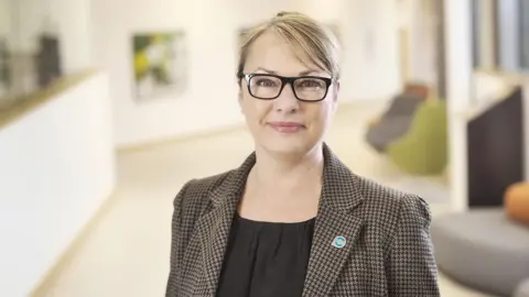 Julian Claxton Dr Melanie Pascale in dark framed glasses