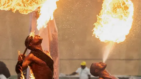 Fire breathers blow flames out of their mouths