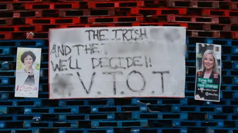 PA Claire Hanna and Michelle O'Neill election posters on a bonfire in south Belfast