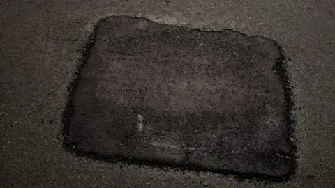 Shaine Tench A fixed pothole in the middle of a road.