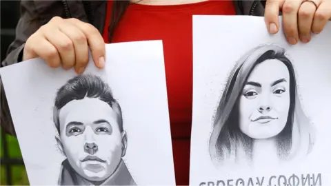 EPA A woman holds a portrait of opposition journalist Roman Protasevich and his girlfriend Sofia Sapega during a protest of solidarity with Roman Protasevic at the Belarusian embassy in Riga, Latvia, 25 May 2021.