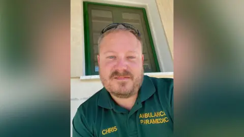 Supplied A man in a green uniform. He has a beard and shades on his head. 