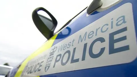 The side of a West Mercia Police car showing the force's logo in blue and white.