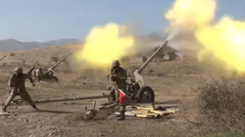 EPA A still image taken from video footage published 20 October 2020 on the official website of the Azerbaijan's Defence Ministry shows allegedly artillery units of the Azerbaijani army fire during military combat with forces of the Nagorno-Karabakh