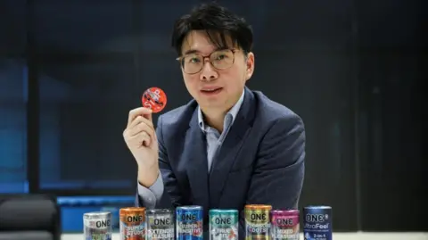 CEO of condom manufacturer Karex, Goh Miah Kiat, poses with condoms manufactured by the company in Malaysia