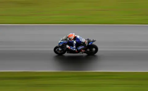 Colin Denholm A superbike racer on a racing track.
