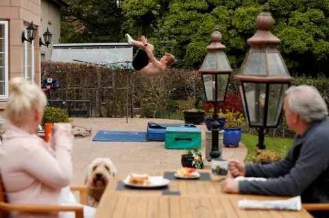 Lee Smith/ Reuters A diver practises at home in the garden as his parents look on