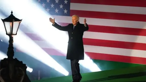 PA Media Joe Biden arrives on stage to deliver a speech in Ballina, on the last day of his visit to the island of Ireland