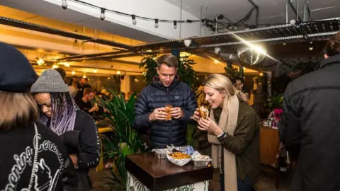 Southwark Council People eat street food at a food court in Peckham Levels