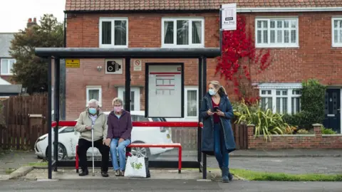 Getty Images People waiting at bus stop