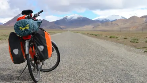 Travel_Nerd Long distance cycling on M41 Pamir Highway, Pamir Mountain Range, Tajikistan. File image