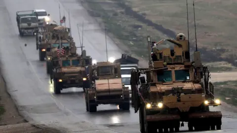 AFP A convoy of armoured personnel carriers in Syria's northern city of Manbij. 30 Dec 2018