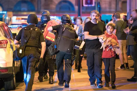 London News Pictures Andrew Roussos with his son outside Manchester Arena following the bomb attack