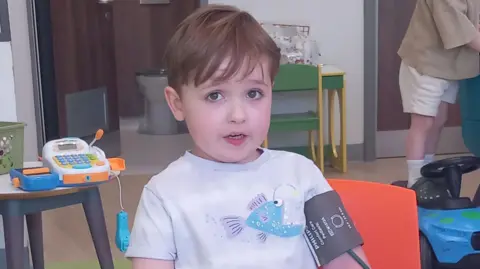 REBEKAH DALRYMPLE Hector with short brown hair, he has a blood pressure monitor on his arm.