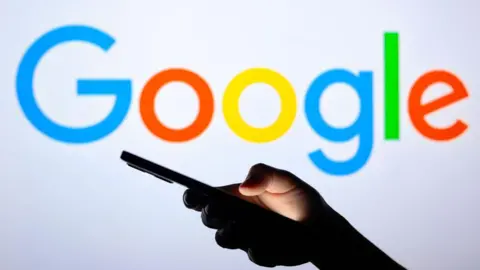 Getty Images مردی تلفن همراه را در مقابل کلمه Google نگه می دارد