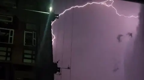 WouldntYouLikeToKnowWeatherboy Lightning off the side of a building - with purple sky behind
