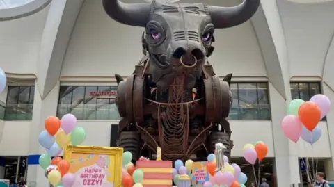 Visit Birmingham Ozzy the bull with balloons and presents around him