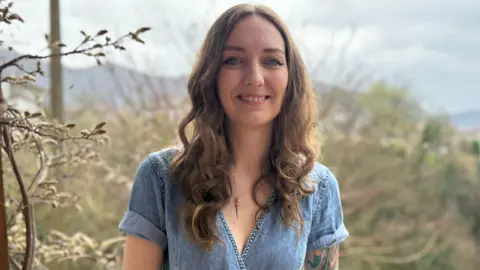 Megan Atkinson Megan Atkinson, stood outside, looking at the camera