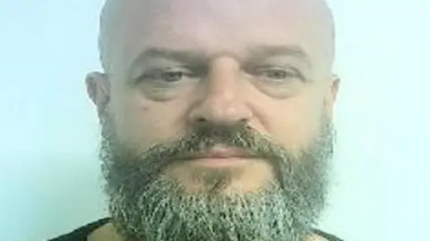 Lincolnshire Police Aaron Wood has a thick grey/black beard and blue eyes