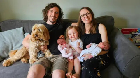 Emily Broughton Emily and husband James with their three children and family dog, called Bailey